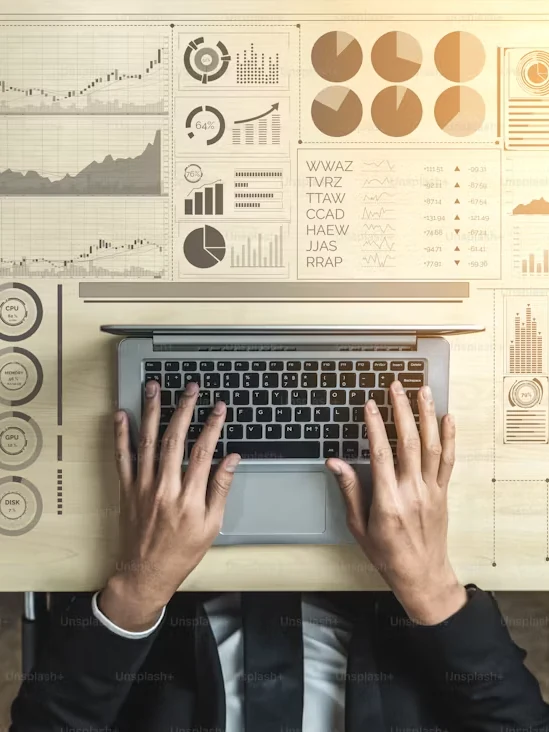 Analyst working on a laptop surrounded by data charts